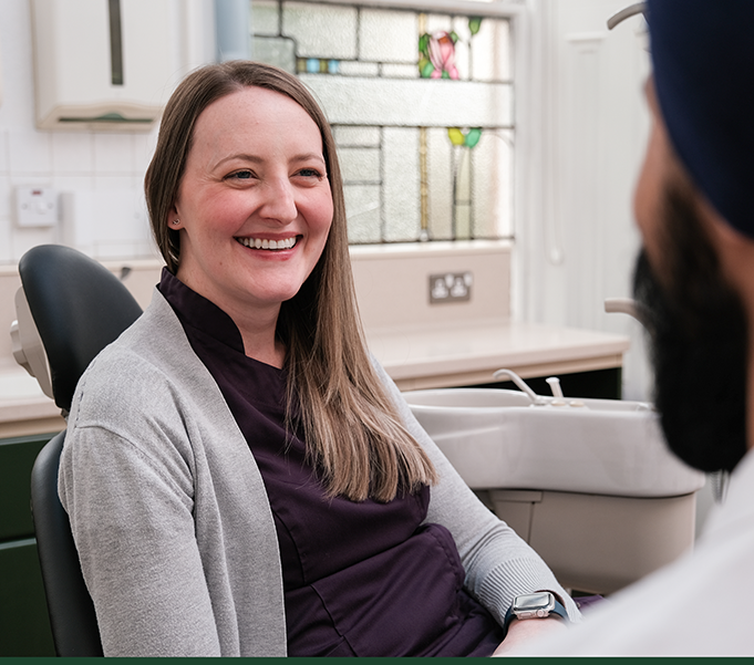 A patient smiling and talking with Dr. Karm Jandoo about their dental treatment plan